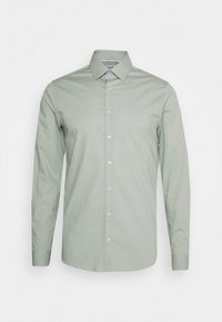 Camicia verde chiaro a maniche lunghe in cotone morbido, con collo e chiusura frontale a bottoni. Logo discreto sul petto.