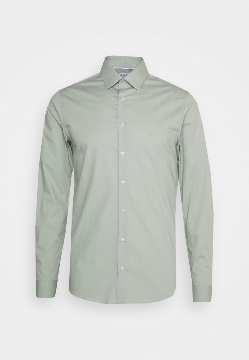 Ljusgrön långärmad skjorta i mjuk bomull, med kragdetalj och knäppning framtill. Diskret logotyp på bröstet.