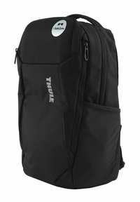 Sac à dos noir Thule avec un design structuré, en tissu durable, poignée supérieure, poches latérales et un logo argenté SafeZone à l'avant.