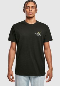 Black cotton t-shirt featuring a graphic design with a hummingbird and text "FLOW OF LIFE" on the left chest area. Short sleeves, crew neck.