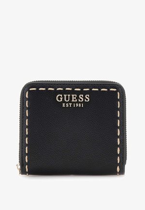 Portefeuille en cuir noir avec lettrage doré "GUESS EST 1981", avec des coutures contrastantes beiges le long des bords et une fermeture zippée.