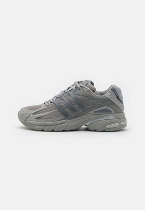 Baskets de sport grises avec empiècements en mesh et synthétiques, fermeture à lacets, semelle coussinée et semelle extérieure texturée, vues de côté extérieur.