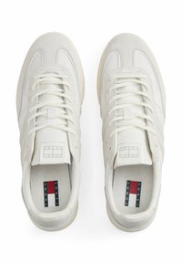 Zapatillas blancas con una mezcla de cuero y ante, con cordones en tono, suela texturizada y marca en la lengua y en la plantilla.