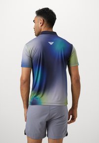 Short-sleeve polo shirt featuring a gradient design in shades of blue, green, and gray with a contrasting logo at the back.