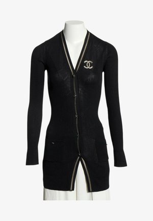 Cardigan noir à manches longues en maille côtelée avec boutons, deux poches avant, bordure beige et logo double-C blanc entrelacé sur la poitrine gauche.