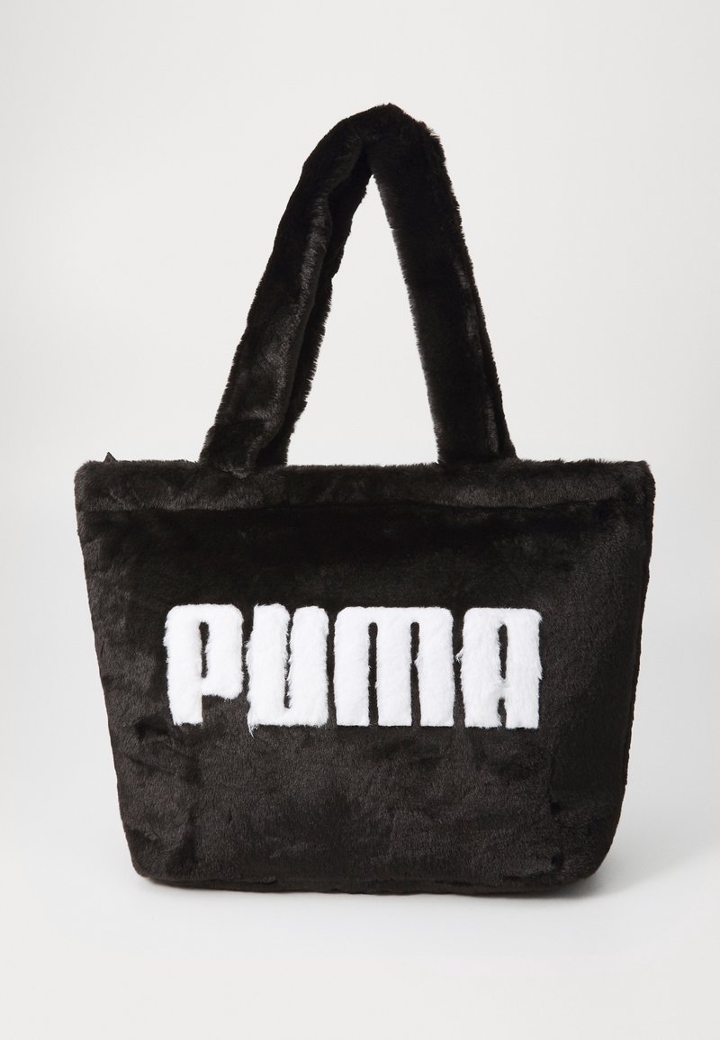 Sac cabas noir en fausse fourrure douce avec deux poignées rembourrées et texte blanc "PUMA" sur le devant.