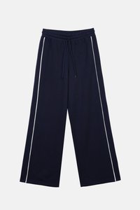 Pantalon large bleu marine en tissu doux avec une taille élastique et un cordon de serrage, présentant des bandes blanches sur les côtés pour le contraste.