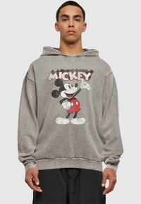 Šedá mikina z bavlny, s vintage grafikou Mickey Mouse na přední straně. Volnější střih, dlouhé rukávy a kapuce na stahovací šňůrku.