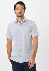 Korte mouw button-up shirt in lichtblauw met een klein geometrisch patroon. Voorzien van een gespreide kraag en vijf decoratieve knopen.