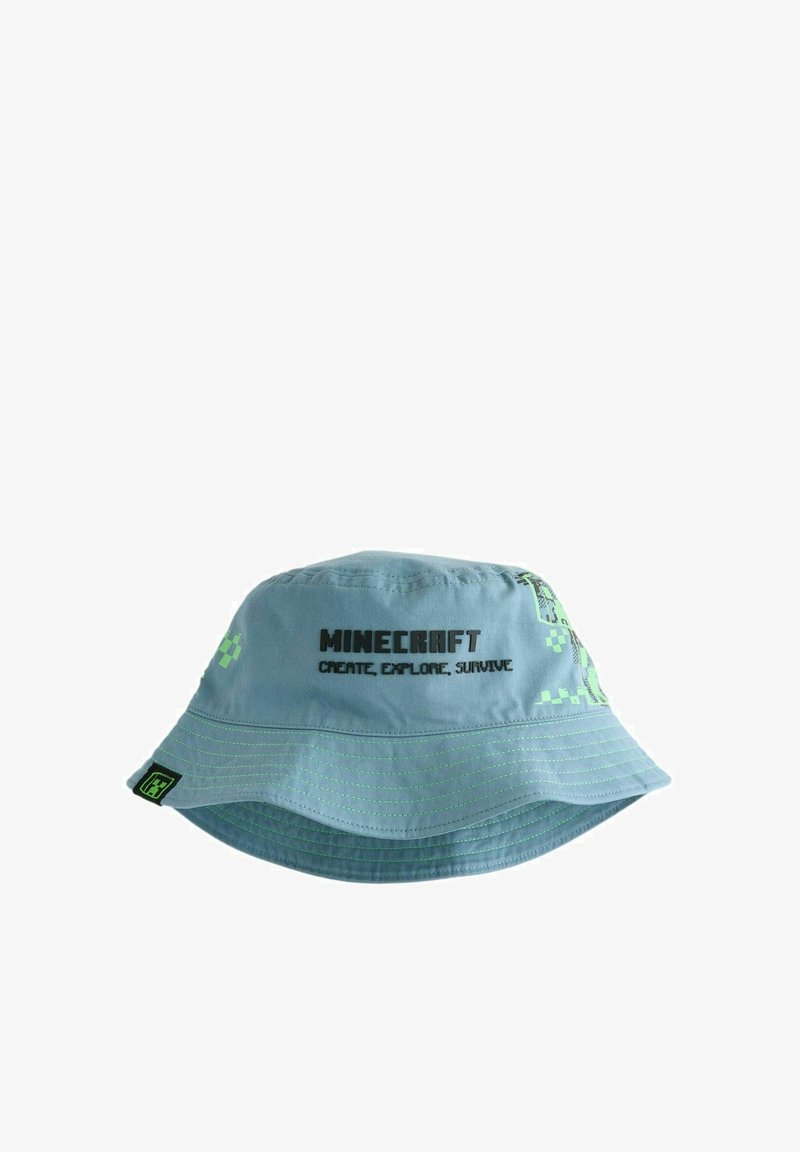 Hele sinine Minecraft'i ämbrimüts roheliste piksliliste mustrite ja musta tekstiga ees, millel on kirjas "Minecraft Create, Explore, Survive".