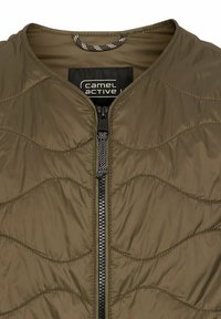 Leichte olivgrüne Jacke mit horizontalem Steppmuster, durchgehendem Reißverschluss und rundem Kragen. Das Innere verfügt über eine kontrastierende Aufhängeschleife.