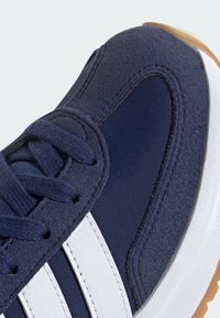 Tamno plave tenisice s teksturiranim gornjim dijelom, glatkim bijelim trakama, okruglim vezicama i izdržljivom gumiranom potplatu s dodatkom boje gume.