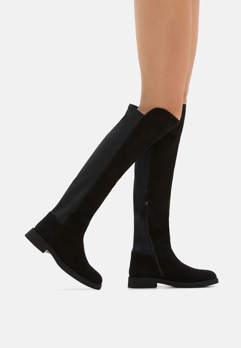 Stivali neri al ginocchio realizzati in una combinazione di suede e tessuto elastico, con cerniera laterale e tacco basso a blocco.