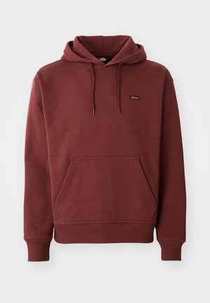 Bordeauxrote Kapuzenpullover aus weichem Stoff mit einer Kängurutasche, gerippten Bündchen und Saum sowie einem kleinen Logostick auf der Brust.