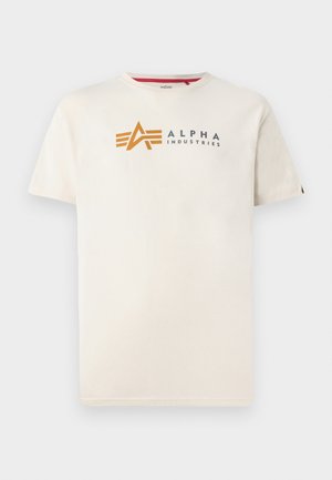 Cream-colored cotton t-shirt featuring a grey and orange "ALPHA INDUSTRIES" logo on the front, with a round neckline and short sleeves.