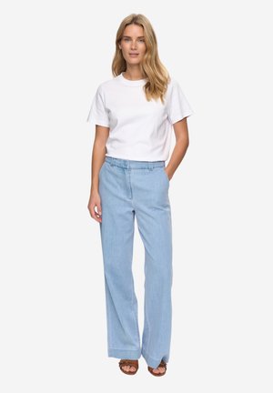 Lyseblå bukser med vide ben og høj talje, kombineret med en tætsiddende hvid t-shirt med rund hals. Simpelt design, afslappet stof og rene linjer.