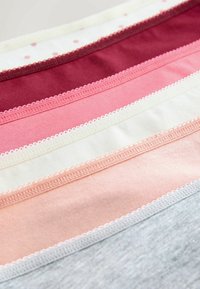 Set aus sechs Baumwolltextilien in verschiedenen Farbtönen: kastanienbraun, rosa, weiß mit Punkten, hellrosa, creme und grau. Jedes mit zarten gewellten Kanten.