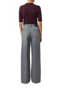 Wide-leg gray denim pants with a high waist, four pockets, and a classic zipper fly, paired with a fitted burgundy short-sleeve top.