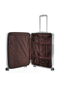 Maleta rodante con un caparazón duro blanco; el interior presenta un forro de tela marrón, un bolsillo con cremallera y correas de sujeción para la organización.