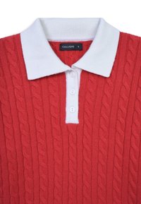 Rotes gestricktes Poloshirt mit weißem Kragen, ausgestattet mit einem Zopfmuster, drei weißen Knöpfen und einem Etikett mit der Aufschrift "CALLIOPE" im Nacken.