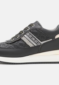 Schwarze Sneaker mit strukturiertem Synthetik-Obermaterial, metallischen silbernen Akzenten, verzierten Details und gemusterten Schnürsenkeln. Mit einer Gummisohle.