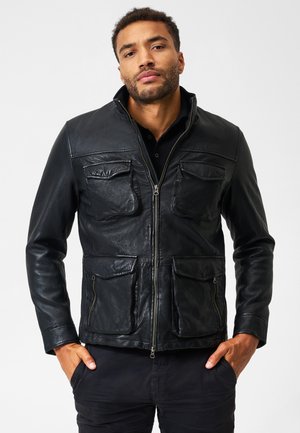 Black leather jacket with zip closure, two chest pockets, and two side pockets. Features a high collar and smooth texture.