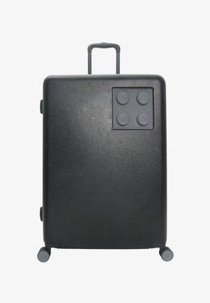 Zwarte harde koffer met een gestructureerde afwerking, voorzien van een uitschuifbare handgreep en vier wielen. LEGO-stijl knoppenaccenten aan de voorkant.