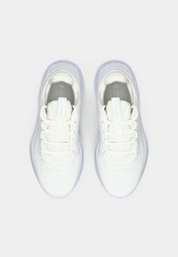 White athletic shoes with a mesh upper, flat laces, and a textured sole. Features include a padded collar and light, breathable design.