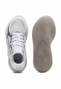 Vita sportskor gjorda av mesh och syntetiskt material, med texturerade grå detaljer, vita snören och en genomskinlig gummisula.