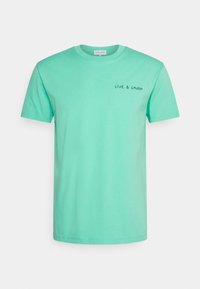 Mátově zelené bavlněné tričko s krátkými rukávy a kulatým výstřihem. Na horní levé straně je vyšívaný nápis "ŽIJ A SMĚJ SE" v černé barvě.