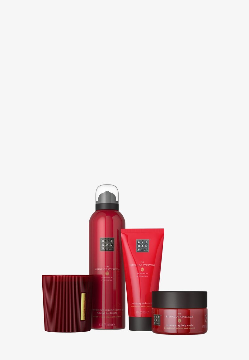 Red Ritual of Ayurveda spa set with foaming shower, body cream, body scrub, and scented candle on white background.