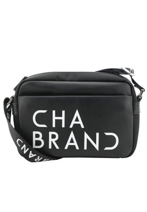 Sacoche noire à porter en travers avec une texture lisse, ornée d'un texte imprimé blanc "CHA BRAND" à l'avant. Sangle ajustable et fermeture éclair.