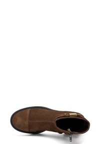 Stivale alla caviglia in suede marrone con punta tonda, tacco basso e zip laterale. Presenta una suola in gomma nera e dettagli di cucitura sottili.