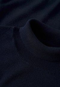 Granatowy sweter dzianinowy z wysokim, ryflowanym kołnierzem. Tekstura jest gładka i miękka, posiada dopasowany krój bez widocznych wzorów.