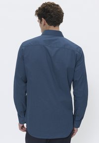 Camicia button-up blu navy con un motivo geometrico, maniche lunghe, colletto standard e polsini bottonati. Tessuto liscio, vestibilità rilassata.