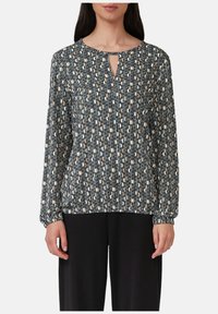 Langärmlige Bluse aus gemustertem Stoff in Dunkelblau, Creme und Gold. Schlüsselbund-Ausschnitt und elastische Bündchen. Lockere Passform.