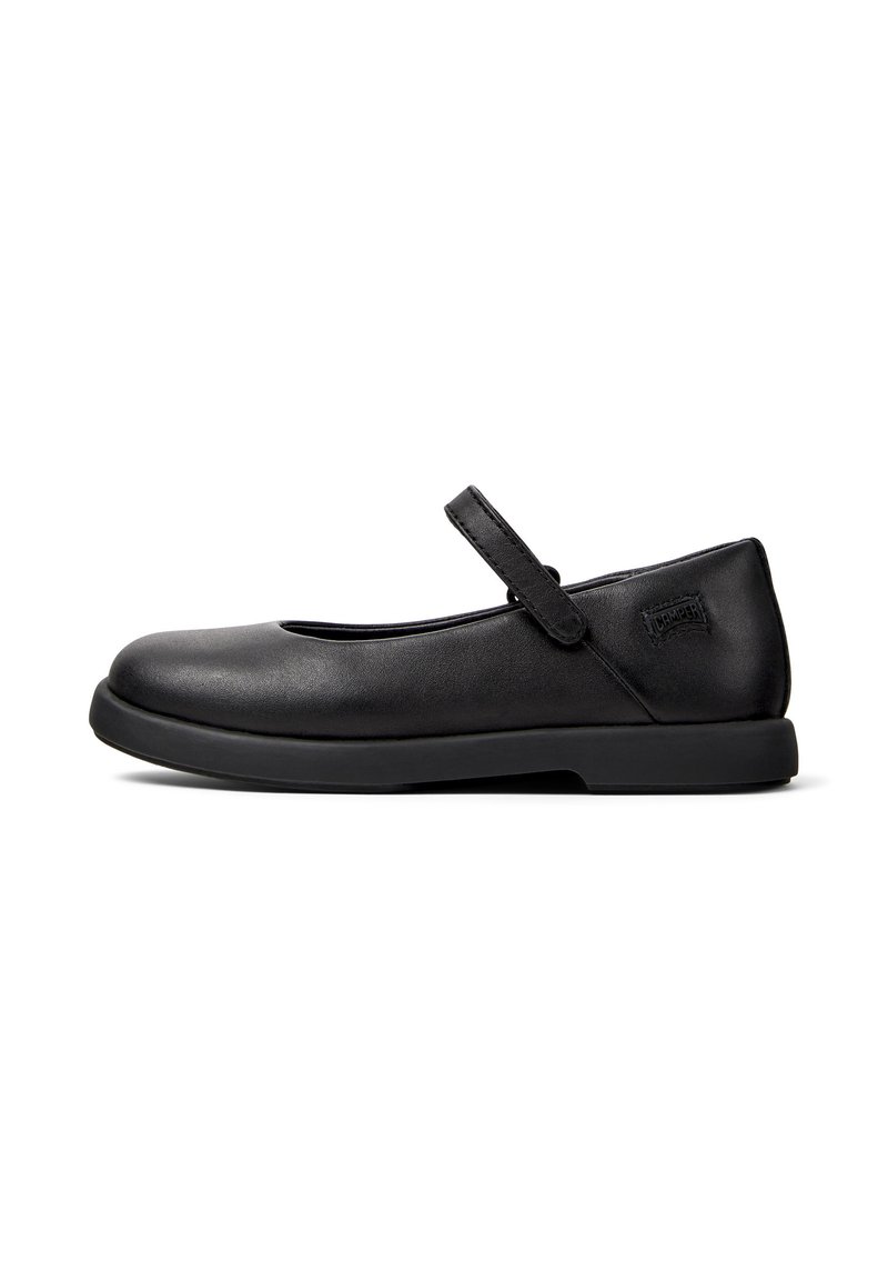Zapato Mary Jane negro con suela plana, punta redondeada y una correa decorativa a lo largo del empeine. Parte superior de piel suave y un sutil detalle del logo.