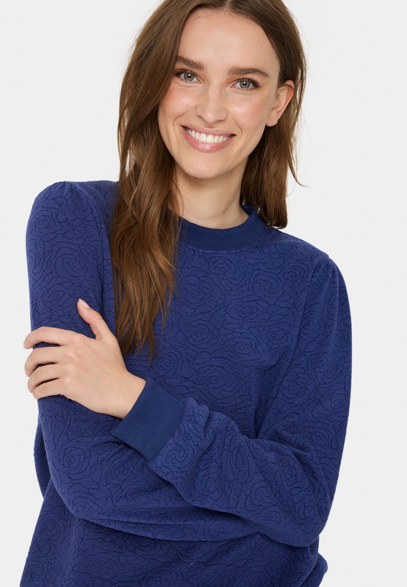 Marineblaues Sweatshirt mit strukturierten Blumenmustern, geripptem Ausschnitt und Bündchen sowie einem entspannten Schnitt, das aus weichem, gemütlichem Stoff gefertigt ist.