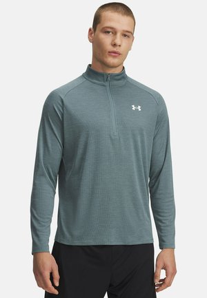 Langharig, met rits gesloten sporttop in teal met een gestructureerd, gestreept patroon. Voorzien van een rechtopstaande kraag, logo op de borst en een ontspannen pasvorm.