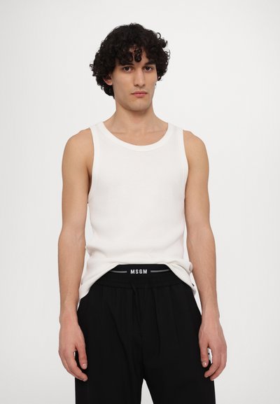 White ribbed tank top with a round neckline, paired with black drawstring pants featuring a branded waistband. Smooth texture, fitted design.