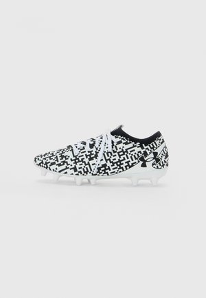 Black and white soccer cleat with pixelated pattern, white laces, black Under Armour logo, and white molded studs on sole.