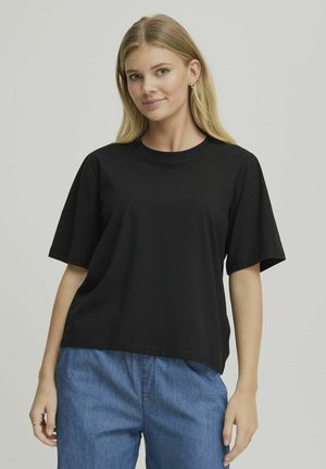Sort kortærmet t-shirt lavet af bomuld, med rund hals og afslappet pasform. Parret med lyseblå denimbukser.