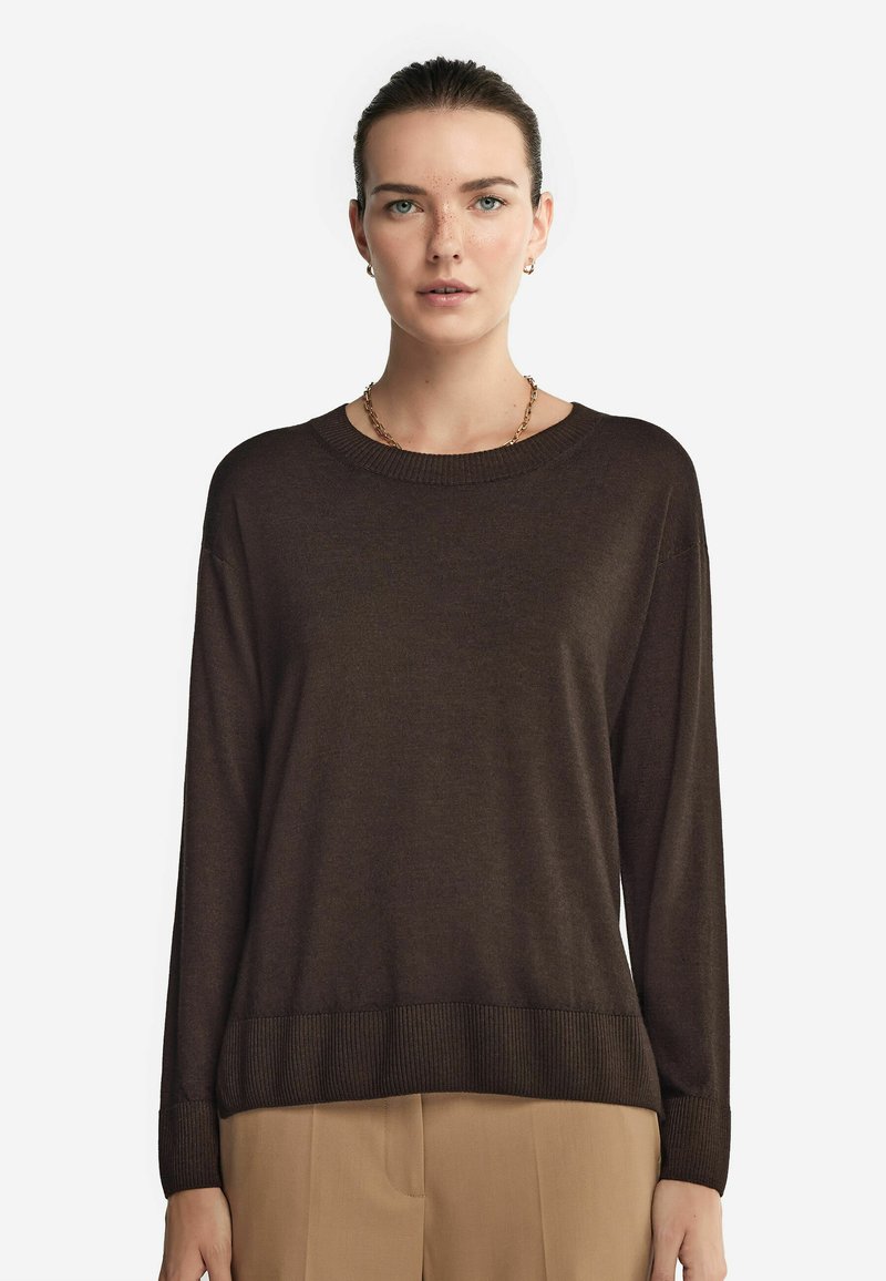 Brauner Pullover mit langen Ärmeln, geripptem Halsausschnitt und Saum, aus einem weichen Material gefertigt. Verfügt über eingesetzte Schultern und eine lockere Passform.