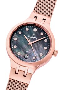 Roza zlata quartz ura s temnim mamo bisernim številčnico, kristalnimi uri označevalci in mrežasto zapestnico. Ima tudi prikaz datuma ob 6. uri.