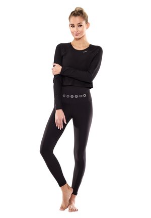 Schwarzes Langarm-Crop-Top, kombiniert mit hoch sitzenden Leggings. Die Leggings haben ein dekoratives Muster am Bund. Glatter, dehnbarer Stoff.