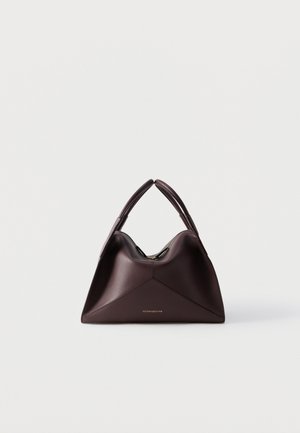 Bolso de cuero marrón oscuro con un diseño geométrico triangular, doble asa superior y un pequeño logo dorado de "Victoria Beckham" en el frente.