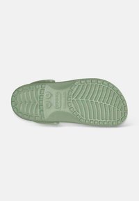 Suola di scarpa in gomma verde chiaro con motivi di battistrada testurizzati e logo, caratterizzata da ondulazioni pronunciate per una migliore aderenza e comfort.