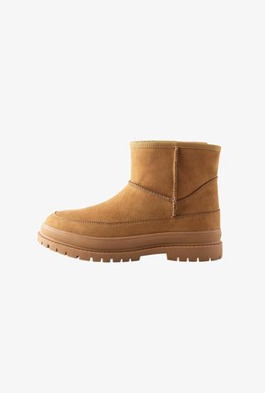 Karamelli suede pahklükk, ümarate varvastega, õmmeldud detailidega, paksu pruuni kummitaldade ja tekstureeritud ülemise äärega.