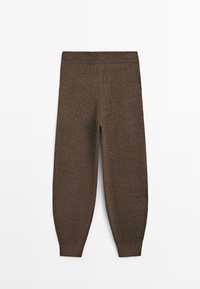 Hnědé pletené kalhoty s elastickým pasem a přiléhavými manžetami položené na rovném bílém pozadí.