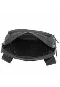 Zaino nero aperto per mostrare il vano principale vuoto con una tasca in rete con cerniera all'interno e spallacci imbottiti sui lati.